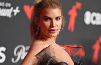 Jessica Simpson combina seu vestidinho preto com saltos em formato de coração com ilusão de ótica