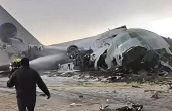 Avião de carga militar que transportava dinheiro cai na estrada e bate em carro, matando 15 pessoas enquanto ladrões pegam dinheiro espalhado