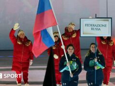 Jogos Paralímpicos de Inverno de 2026: Atletas da Rússia e da Bielo-Rússia desfilam atrás de bandeiras nacionais na cerimônia de abertura.