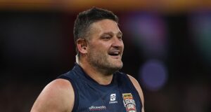 Assista ao momento em que a lenda do futebol Brendan Fevola cai no chão devido a um problema de saúde MUITO doloroso na rádio ao vivo