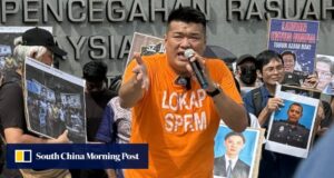 O empresário malaio divulgou uma foto do policial armado, provando que ele estava sob a mira de uma arma.