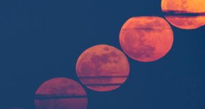 A lua cheia de março brilha vermelha através da poeira do Saara