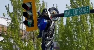 Vídeo mostra a motocicleta pairando sobre um semáforo depois que o ciclista colidiu e voou pelo ar, ferindo-o gravemente