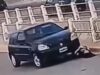 No momento em que uma mulher verifica a bateria do carro, o próprio motor atropela após conectar o cabo auxiliar