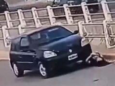 No momento em que uma mulher verifica a bateria do carro, o próprio motor atropela após conectar o cabo auxiliar