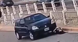 No momento em que uma mulher verifica a bateria do carro, o próprio motor atropela após conectar o cabo auxiliar