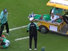Um carrinho médico passa para um jogador