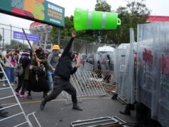 O caos se instalou do lado de fora do estádio da Copa do Mundo no México. Imagem de manifestantes jogando objetos contra a polícia.