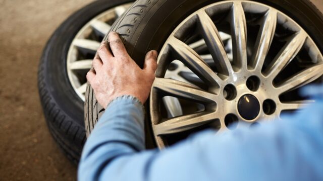 garage-mechanic-examining-car-tyre-1000232010.jpg