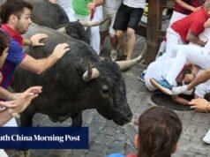 Um corredor leva um soco no rosto no festival de corrida de touros de San Fermin, na Espanha.