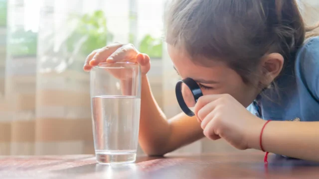 child-examines-drinking-water-with-magnifying-glass.webp.webp