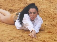 A peituda Charli XCX quase tira a camisa azul e se contorce na areia com uma calcinha preta enquanto filma o videoclipe mais sexy de todos os tempos