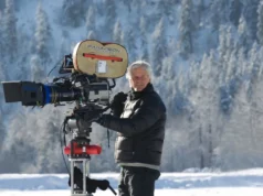 Chris Carter, o criador de “Arquivos a man in winter clothing holding a large film camera outside in a snowy forest landscape