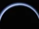 A atmosfera de Plutão entra em colapso à medida que se afasta do Sol e entra em um estado de congelamento profundo a hazy blue ring of light on a black background